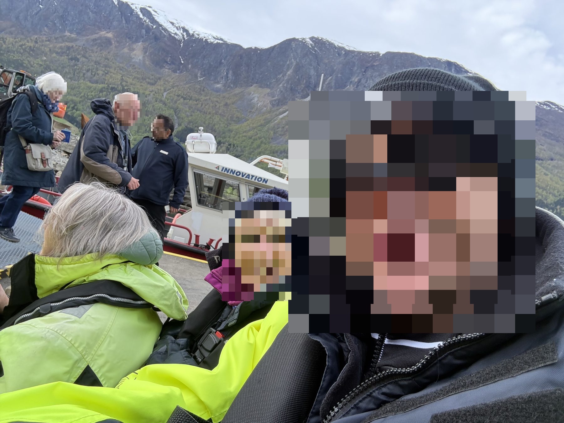 Selfie of Son with Mum behind, mountains and INNOVATION boat in background